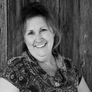 Femme sourainte accoté sur un mur de bois