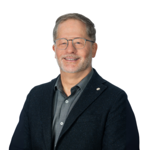 Homme avec large sourire sur un fond blanc.