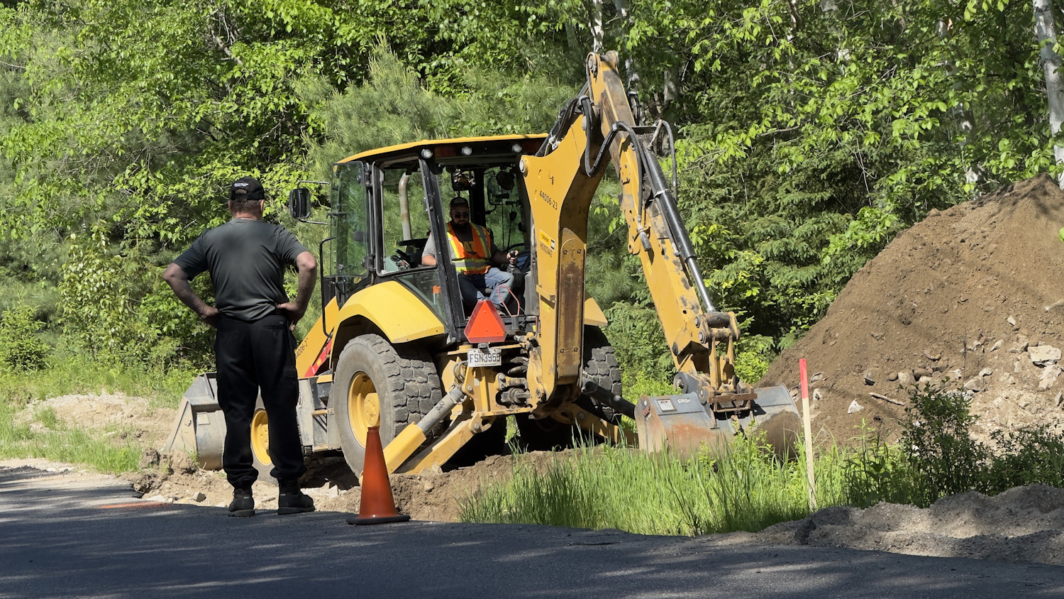Un employé s’affaire sous les yeux attentifs d'un citoyen au ponceau endommagé près du poste de Bell sur le Chemin de la Rivière Nord.
(Photo Medialo - Ronald McGregor)