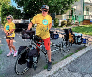 Un homme sur un vélo plein de sacoches avec une femme à ses côtés