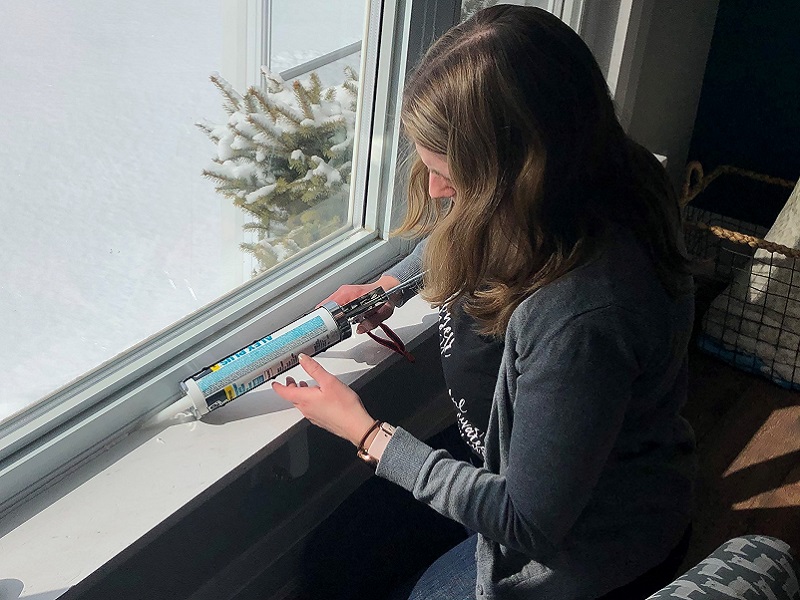 homeowner caulks around window